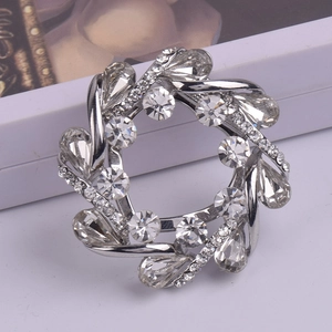 Élégante broche couronne argentée avec strass blancs et cristaux en forme de poire