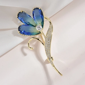 Detailansicht der Blumenbrosche mit blauen Kristallblättern und Zirkonia-Blättern