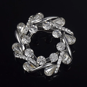 Broche couronne de fleurs argentée avec cristaux étincelants sur fond noir réfléchissant