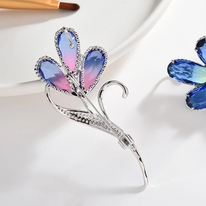 Eleganter Zirkon-Blumenbrosche mit Kristallblüten auf weißem Tablett-Hintergrund