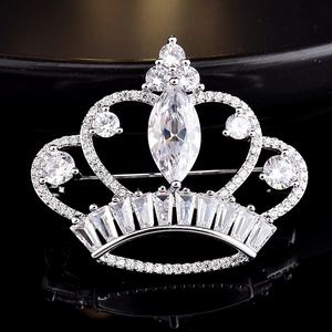 Macro shot of silver crown brooch with marquise cut crystal and pave zircon details