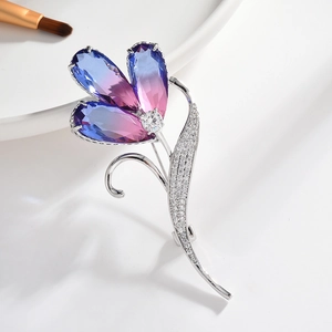 Eleganter Blumenanstecker mit blau-violetten Kristalltropfen und silberner Mikropflasterung