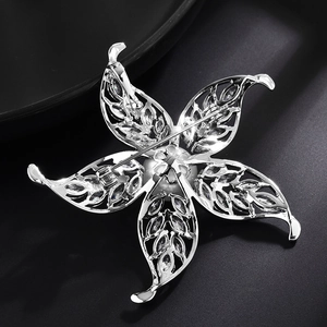 Détail du fermoir à épingle au dos de l'élégante broche fleurie ornée d'une perle