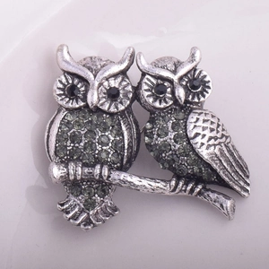 Détail de la broche hibou rétro avec strass gris et métal argenté à l'aspect vieilli