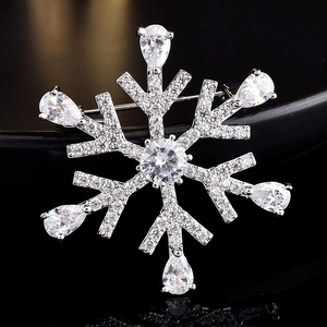 Macro detail of snowflake brooch with silver metal base and clear pear-cut gemstones