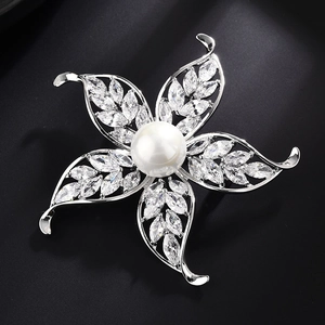 Broche florale élégante avec perle blanche et oxydes de zirconium sur fond noir mat