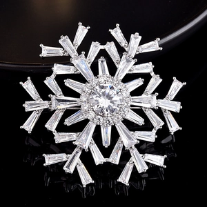 Macro shot of silver snowflake brooch with sparkling cubic zirconia and multi-layer design