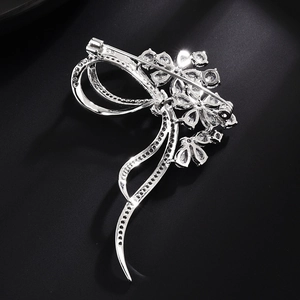 Elegant silver flower bow brooch with sparkling cubic zirconia stones on black background