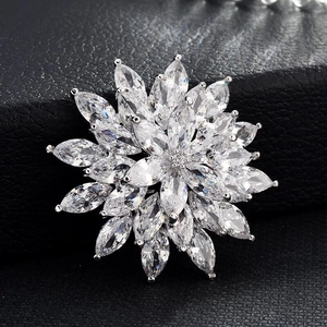 Gros plan sur une broche fleur élégante avec zircons marquise sur cuir noir texturé