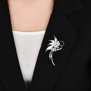 Elegant silver flower brooch with white zircons on a black suit jacket for women