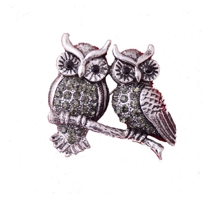 Broche double chouette rétro avec cristaux verts et métal argenté sur fond blanc