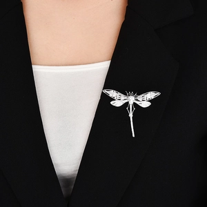 Élégante broche libellule argentée sertie de zircons sur le revers d'un blazer