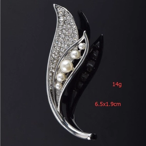 Détail d'une broche fleur argentée montrant les dimensions 6.5x1.9cm et le poids 14g