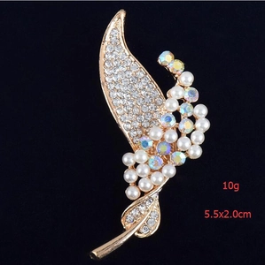 Détail de la broche feuille avec cristaux scintillants et perles sur alliage doré