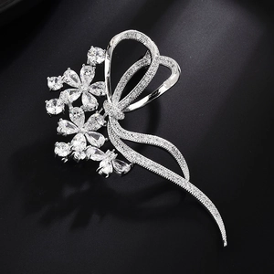 Detail of silver ribbon flower brooch with sparkling cubic zirconia on black background