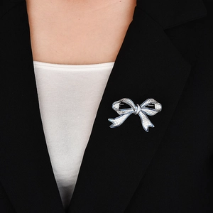 Broche nœud élégante en argent avec émail bleu et zircons sur revers de veste noir