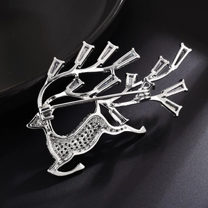 Vue macro de la broche cerf en argent avec bois en zircon sur un fond noir texture