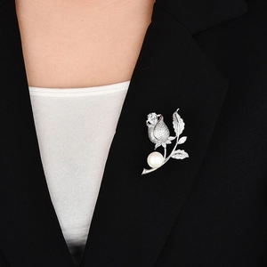 Eleganter Rosen-Anstecknadel mit Zirkonia und Perle an einem schwarzen Damen-Blazer