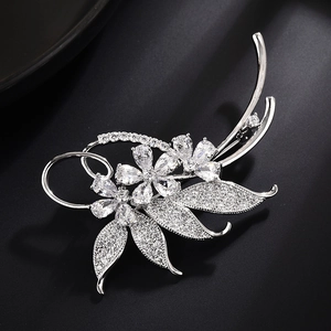 Elegant silver flower brooch with pearls and sparkling crystals on a sleek black background