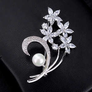 Macro di una spilla a fiore argento con zirconi marquise brillanti e una perla bianca