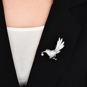 Elegant bird brooch in silver finish with pavé zircon stones pinned on a black suit
