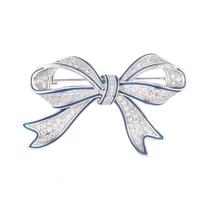 Élégante broche nœud papillon avec zircons et détails en émail bleu sur métal