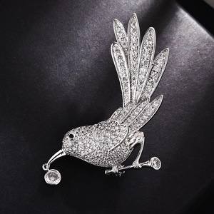 Elegant bird brooch with sparkling cubic zirconia on a black leather gift box