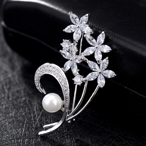 Elegante spilla floreale con fiori di zircone e perla bianca su sfondo in pelle nera