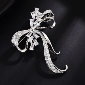 Broche nœud élégante en argent avec zircons et cristaux baguette sur fond noir profond