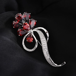 Elegant floral brooch with red pear-cut gems and white zircon inlay on silver base