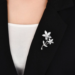 Elegant floral zircon brooch in silver finish pinned on a black suit lapel for women