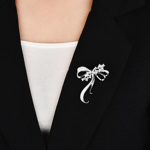 Élégante broche nœud en argent sertie de zircons sur le revers d'un tailleur noir