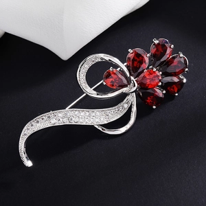 Elegant silver flower brooch featuring pear-cut red zircon petals and micro-pave accents