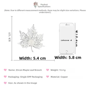 Detailed macro view of maple leaf pearl brooch dimensions compared with a mobile phone