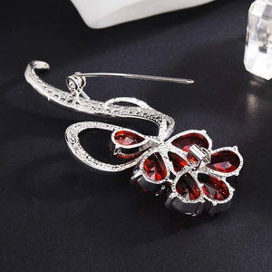 Elegant silver brooch with red pear-shaped zircon stones and secure pin clasp design