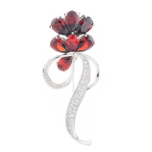 Elegant flower brooch with pear-cut red zircon petals and silver ribbon details on white