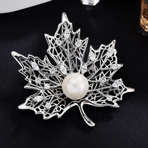 Elegant maple leaf brooch with silver hollow metal, large white pearl and sparkling zircons