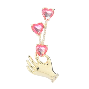 Elegant gold-tone hand-shaped brooch featuring pink heart crystals and white rhinestones