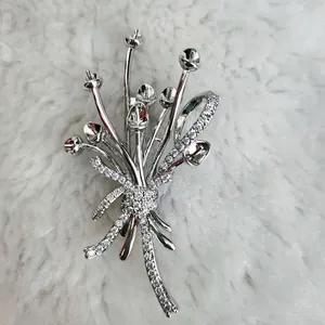 Détail de la broche bouquet de fleurs avec zircons étincelants et ruban argenté élégant
