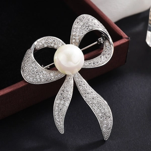 Elegante silberne Schleifenbrosche mit Zirkonia-Steinen und einer weißen Perle für Anzüge