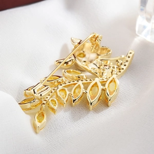 Elegante goldene Hirsch- und Blatbrosche mit gelben Steinen und Nadelverschluss