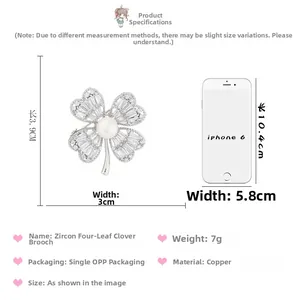 Detailed size comparison of clover zircon brooch with pearl center next to iPhone 6
