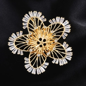 Detail shot of a flower-shaped gold brooch base with sparkling cubic zirconia inlay