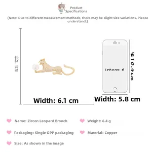 Size comparison of a gold cheetah brooch with white zircons and a white pearl