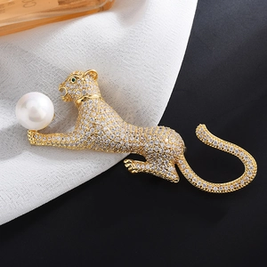 Elegant gold leopard brooch with white crystals, green eyes, and a large white pearl detail