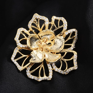 Gros plan détaillé d'une broche fleur dorée avec accents en micro-zirconium