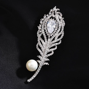 Detailed close-up of a silver feather brooch with pear-cut stone and a white pearl