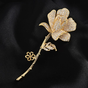 Détail d'une broche rose dorée avec oxydes de zirconium sur fond en soie noire