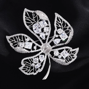 Macro shot of leaf-shaped brooch setting with cubic zirconia on black silk background