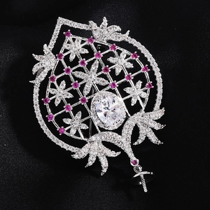 Détail de la base de broche cœur sertie de zircons avec support perle sur tissu noir